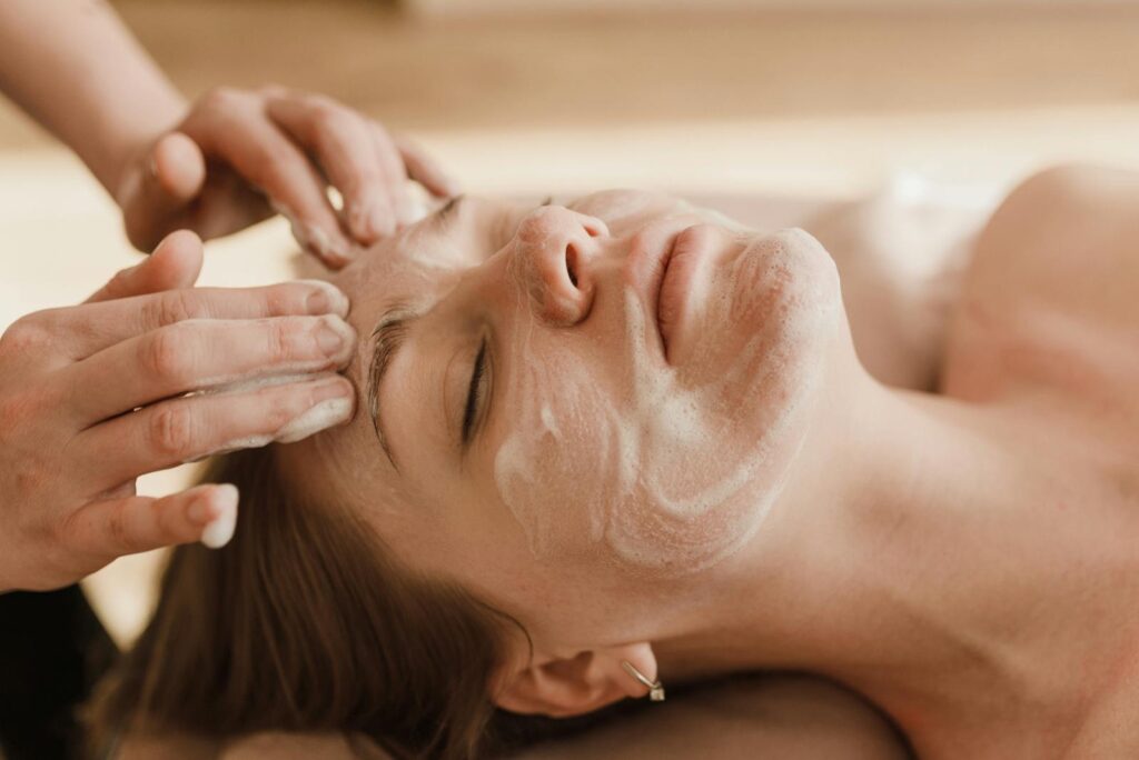 Photo by Arina Krasnikova A close-up of a woman receiving a soothing facial massage with a skincare mask.